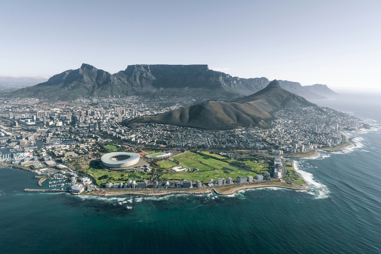 City nestled near a mountain range, representing the diverse landscapes experienced by Americans living in South Africa.