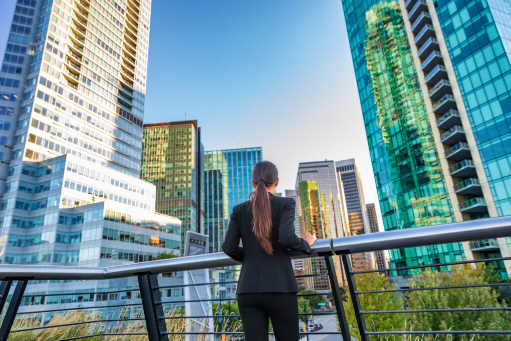 Businesswoman overlooking the Vancouver skyline, thinking about starting a business in Canada.