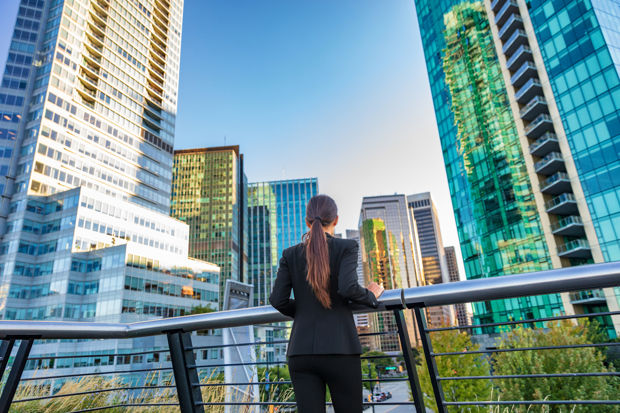 Businesswoman overlooking the Vancouver skyline, thinking about starting a business in Canada.