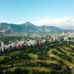 City skyline with a golf course and mountains, capturing the lifestyle enjoyed by many Americans living in Chile.