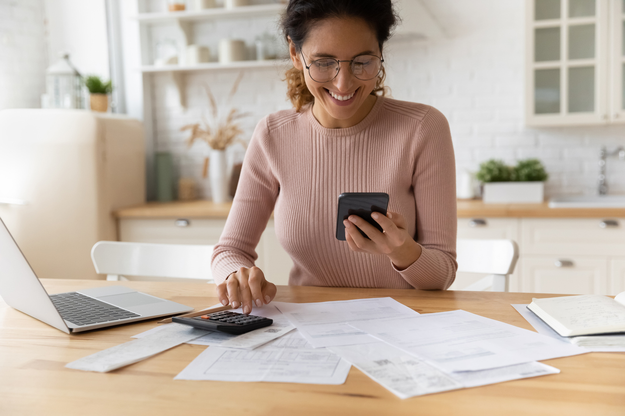 Young woman smiling after a successful mobile transaction—embracing modern banking, finances, and taxes in the UK.