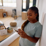 Relaxed and happy woman checks her phone after moving, embracing her new life in Canada.