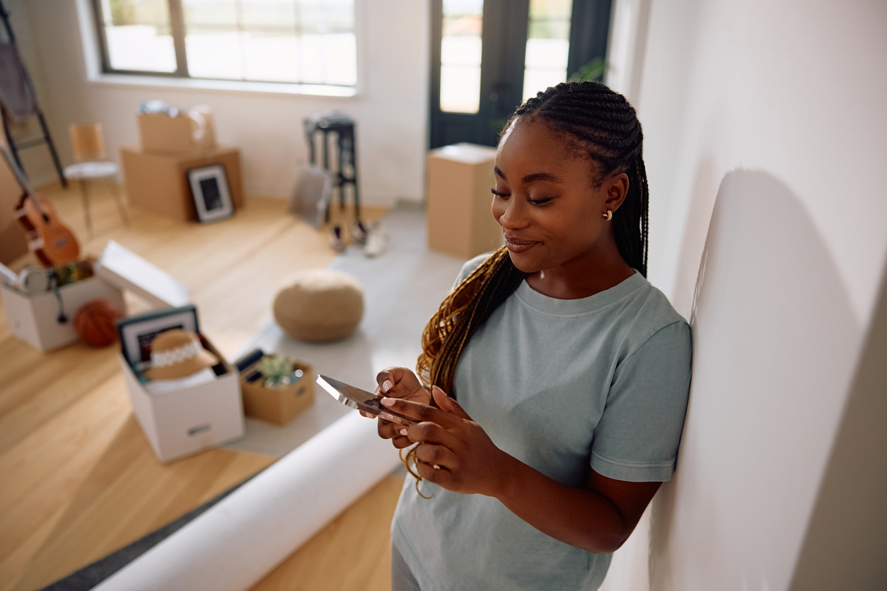 Relaxed and happy woman checks her phone after moving, embracing her new life in Canada.