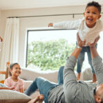 Young family playing on the living room floor, enjoying the everyday moments of raising a family UK style.