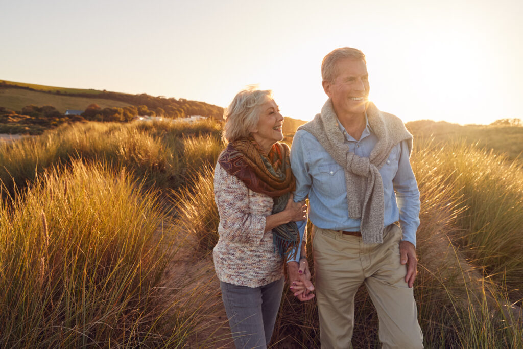 Golden hour walk on the beach, reflecting the joy and connection of those who retire in the UK.