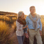 Golden hour walk on the beach, reflecting the joy and connection of those who retire in the UK.