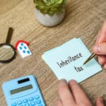 Real estate and financial documents on a desk, representing planning and reporting around foreign inheritance tax.