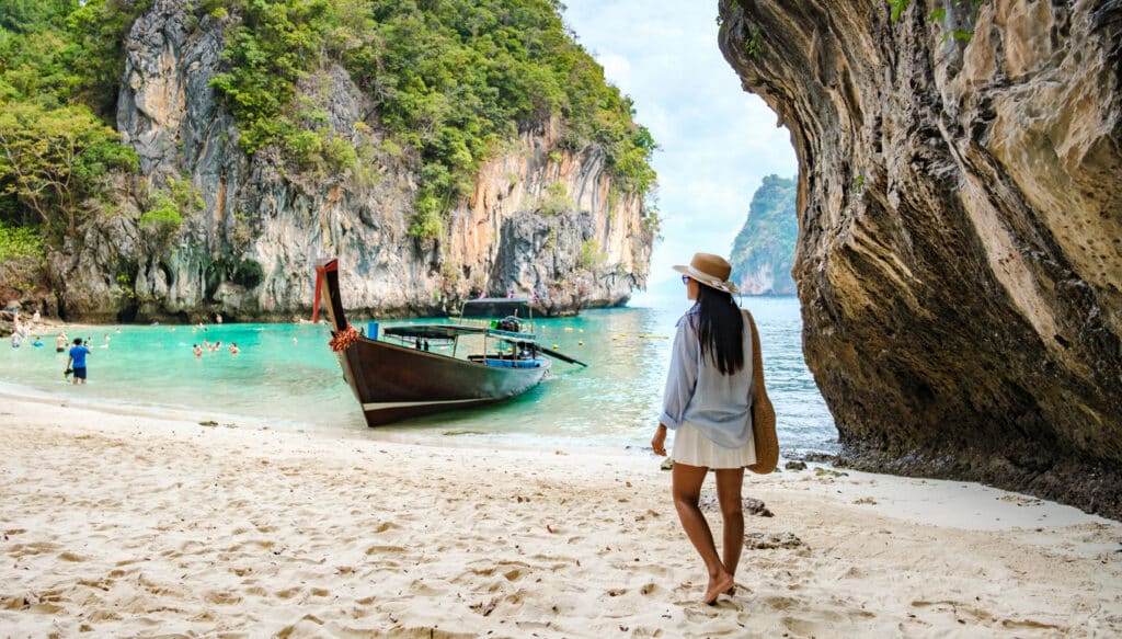 Crystal-clear water, limestone cliffs and soft sand on a Thai island, reflecting the tropical lifestyle many Americans living in Thailand enjoy alongside local travelers.