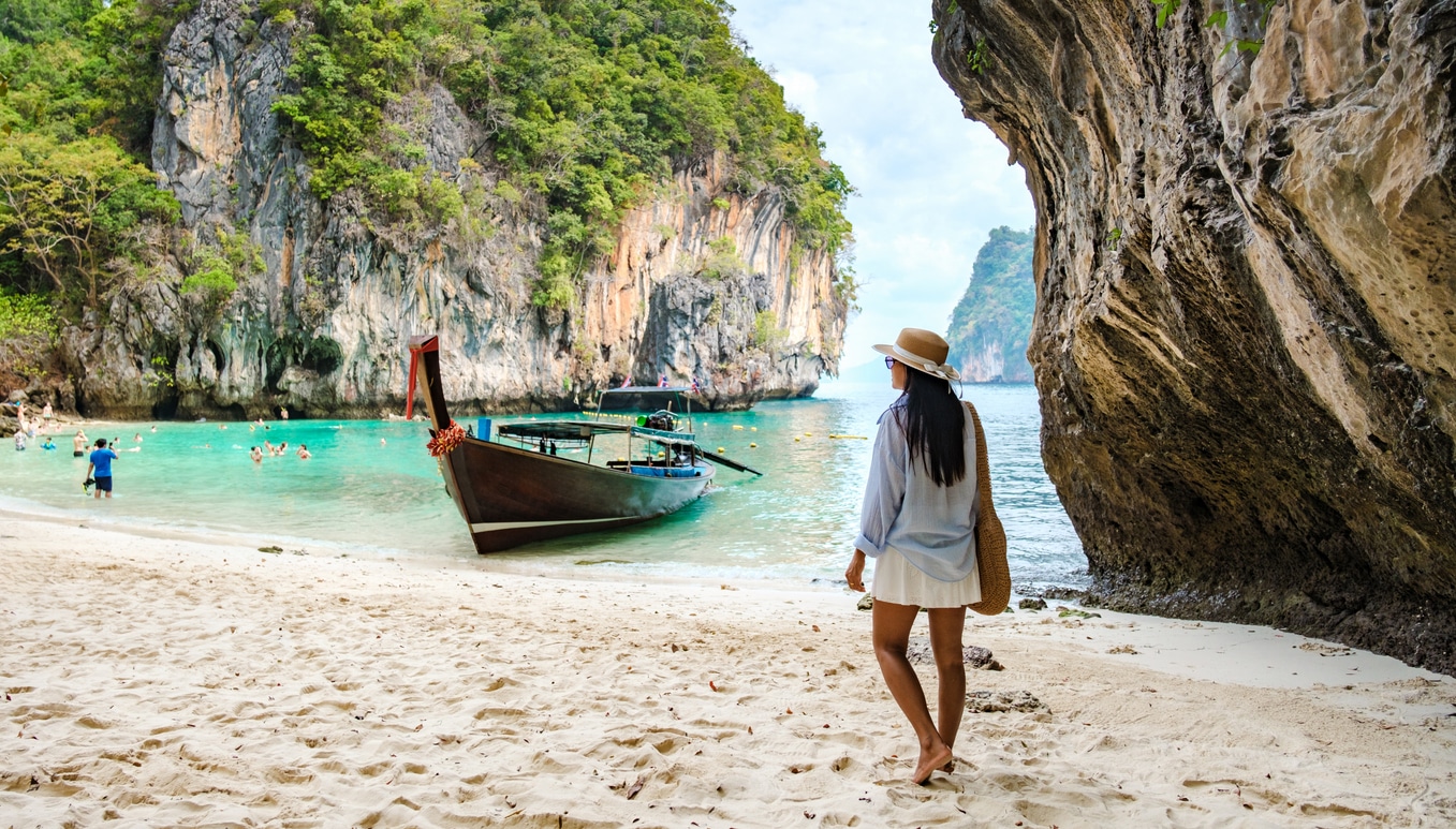 Crystal-clear water, limestone cliffs and soft sand on a Thai island, reflecting the tropical lifestyle many Americans living in Thailand enjoy alongside local travelers.