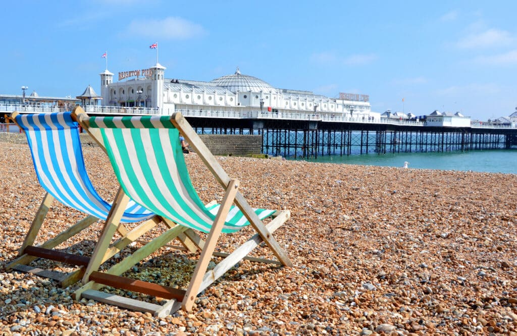 Sun loungers lined up on Brighton beach, evoking the relaxed seaside lifestyle many people consider when researching the best places to retire in the UK.