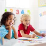 Preschoolers practicing reading and writing with their teacher, reflecting early education standards in the best schools in Germany.