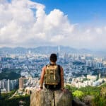 Man looking out over a sprawling city view from the mountains, capturing the scale and energy of life for Americans living in China.