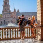 Family walking through Plaza de España in Seville while staying abroad, tying into the idea of a nonresident income tax return.