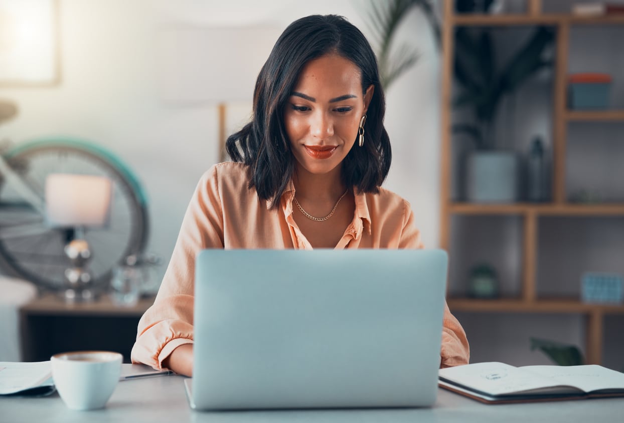 Woman working alone in an office on her laptop, reviewing figures related to foreign tax credit calculation.