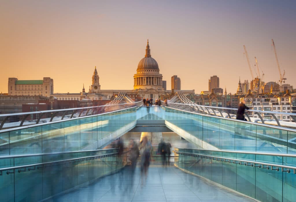 Sunset view of Millennium Bridge and St Paul’s Cathedral in London, representing the destination many professionals move to on a UK work permit visa.