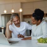 Two colleagues reviewing financial work together, reflecting the kind of planning needed to avoid an IRA early withdrawal penalty.