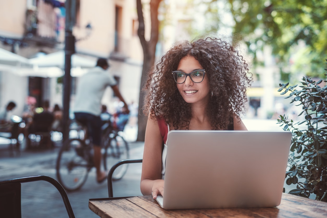 Freelancer working on a laptop at an outdoor café, representing the income planning decisions affected by marginal tax rates.