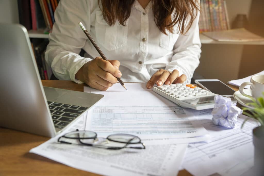 Tax forms, calculator and calendar on an office desk, highlighting the October 15 tax deadline.