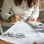 Tax forms, calculator and calendar on an office desk, highlighting the October 15 tax deadline.